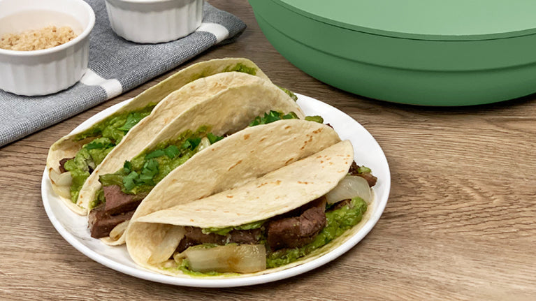 Prime Rib Tacos on a plate with The pan in Green behind the plate
