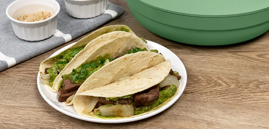 Prime Rib Tacos on a plate with The pan in Green behind the plate