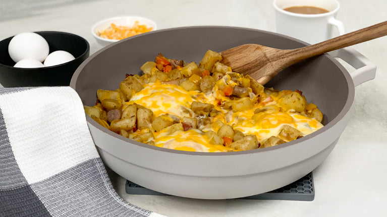 Savoury One-pan Breakfast Skillet Recipe inside of The Gray Pan with The Spoon surrounded by Coffee and eggs